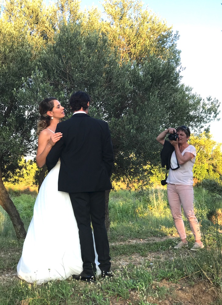 Nathalie Rabotot en plein reportage, photographiant un couple de mariés dans une oliveraie à la lumière du soir
